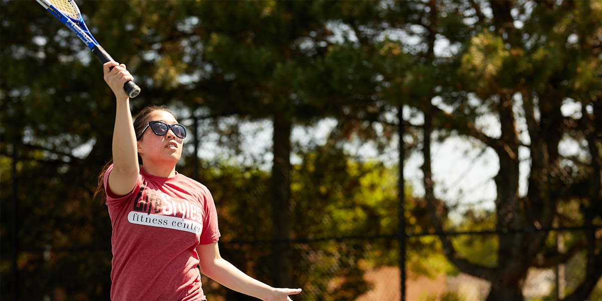 white young female hitting tennis ball over net