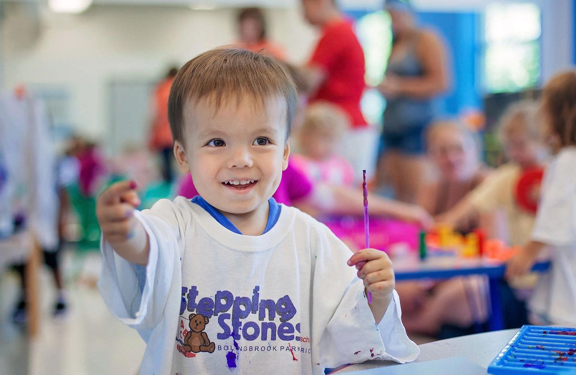 young white toddler boy holding paint brush in preschool program young white toddler boy holding paint brush in preschool program
